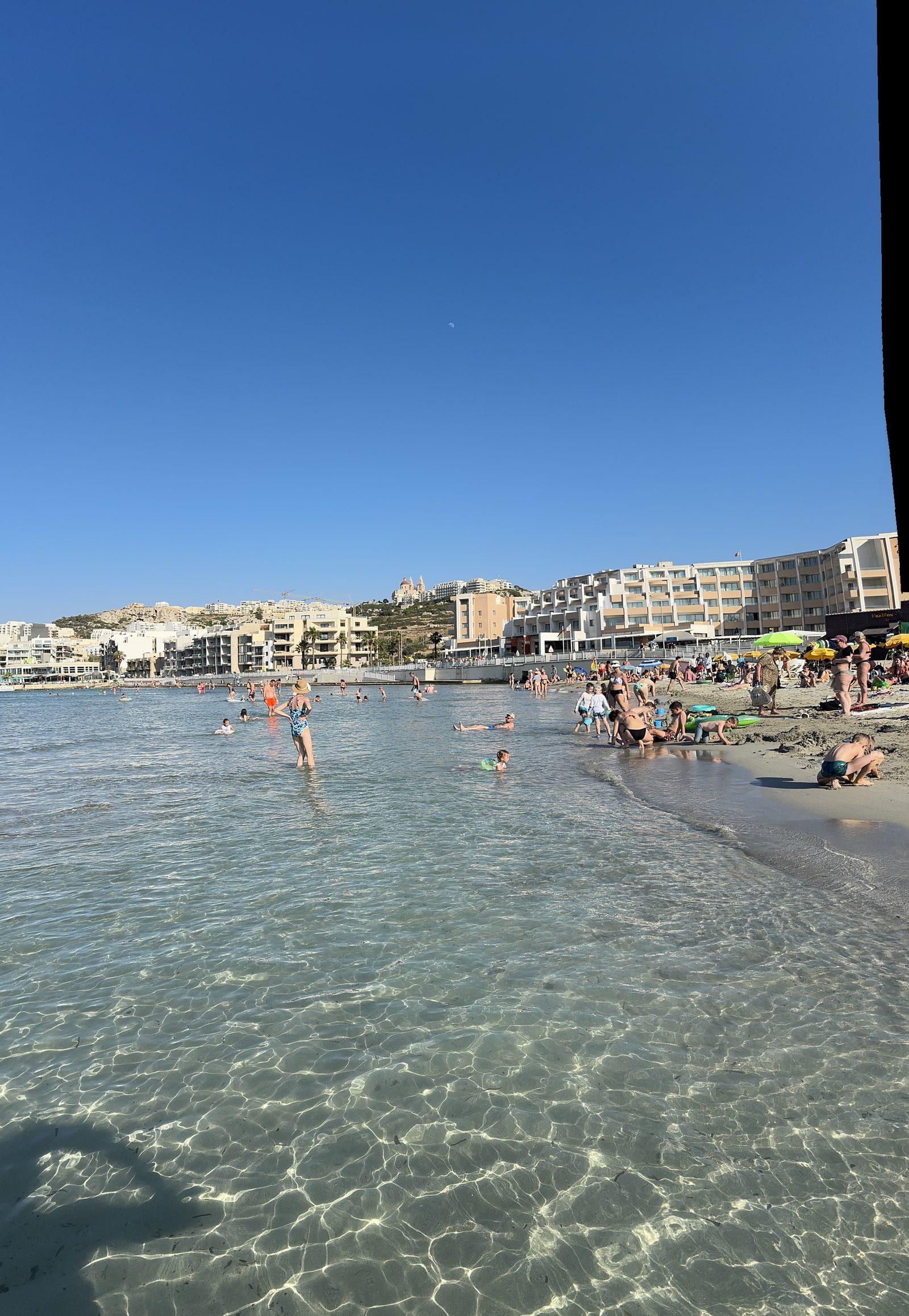 Mellieha Bay (Għadira): arena fina, poca profundidad y la iglesia del pueblo en lo alto