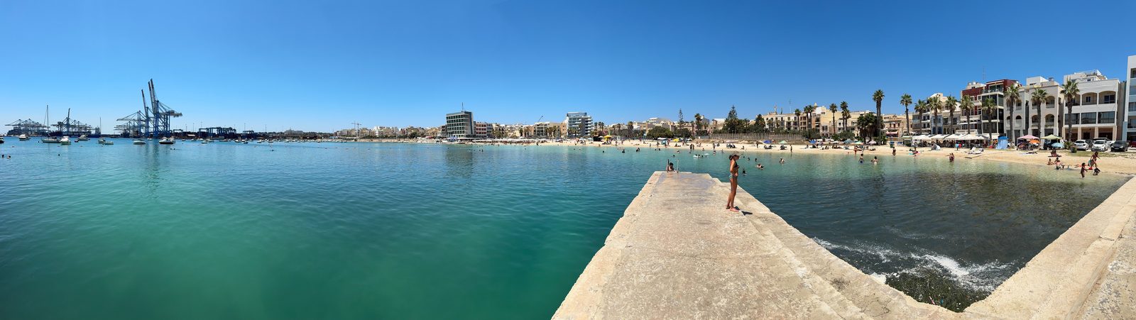 Pretty Bay, en la vecina Birżebbuġa, con las grúas del Freeport al fondo
